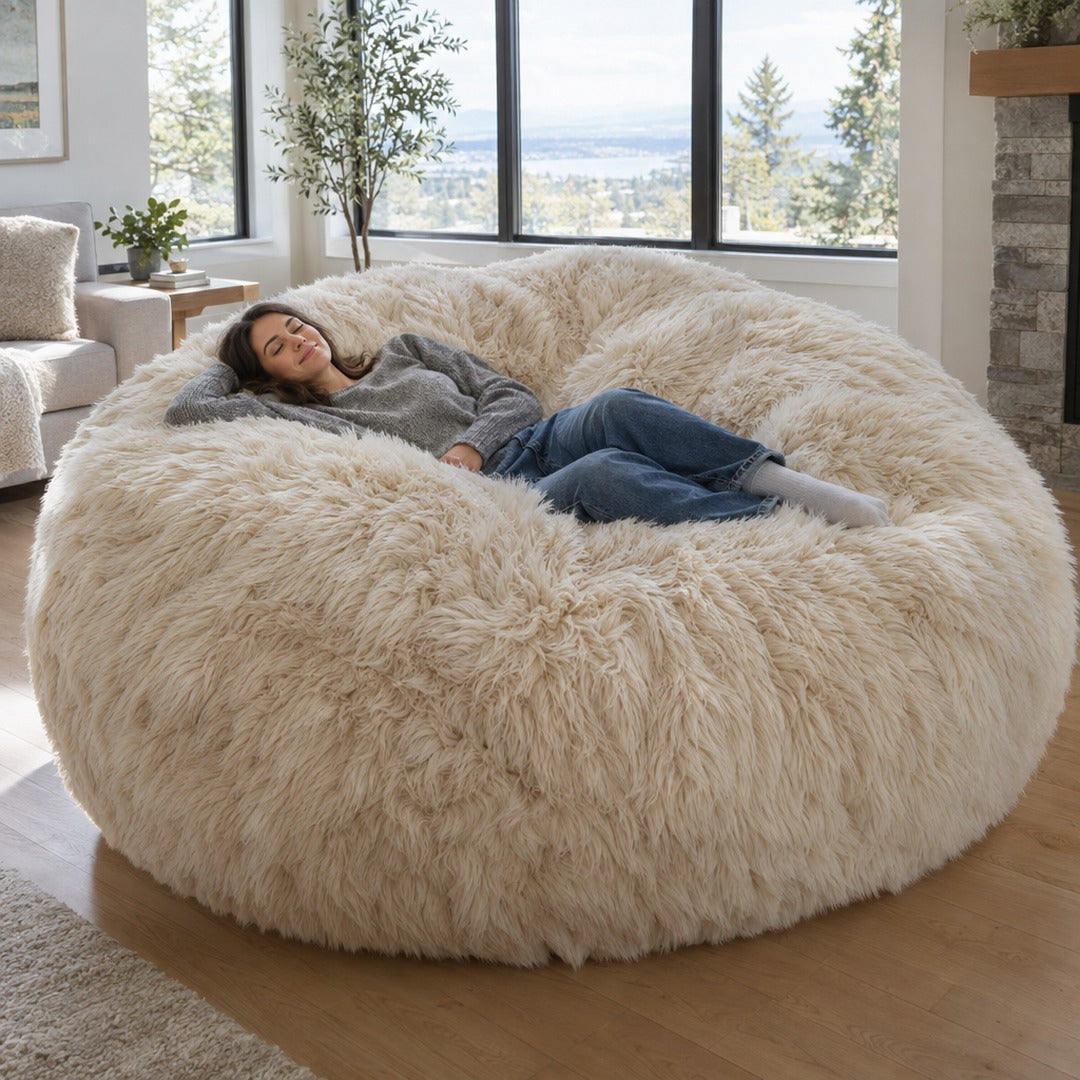 Giant 8 ft faux fur bean bag in Beige with a woman lying across it in a living room