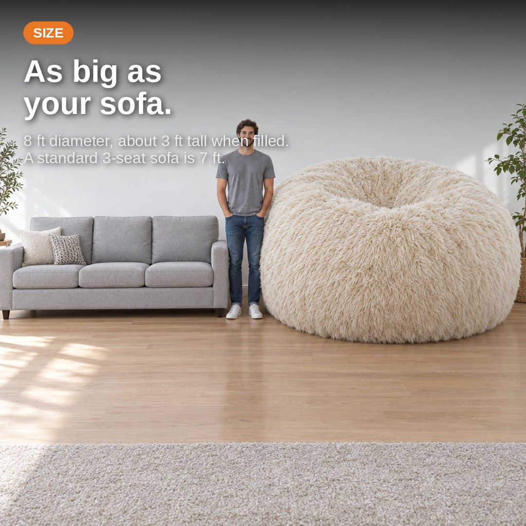 Size comparison: the 8 ft bean bag next to a three-seat sofa and a standing adult