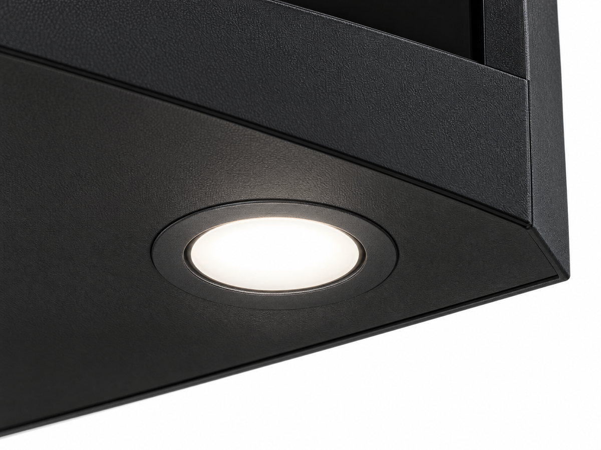 Close-up of one recessed warm-white downlight in the black underside panel