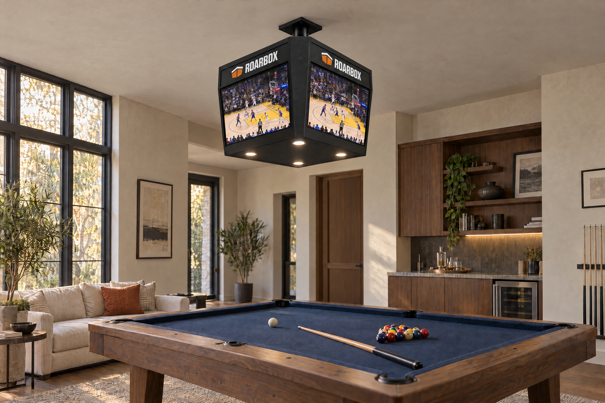 The unit mounted above a pool table in a games room, basketball on the screens